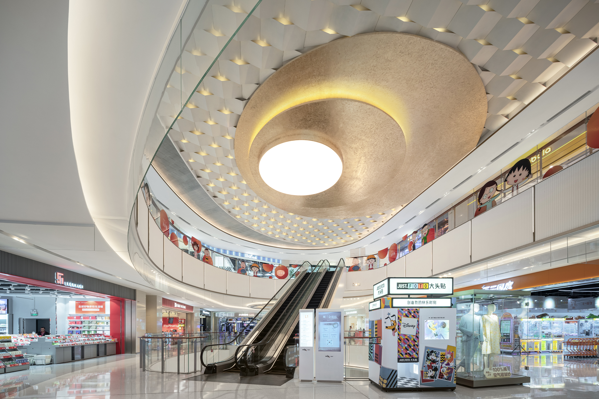 现代购物中心内部多层结构，透明玻璃天窗顶棚和扶梯连接各楼层。