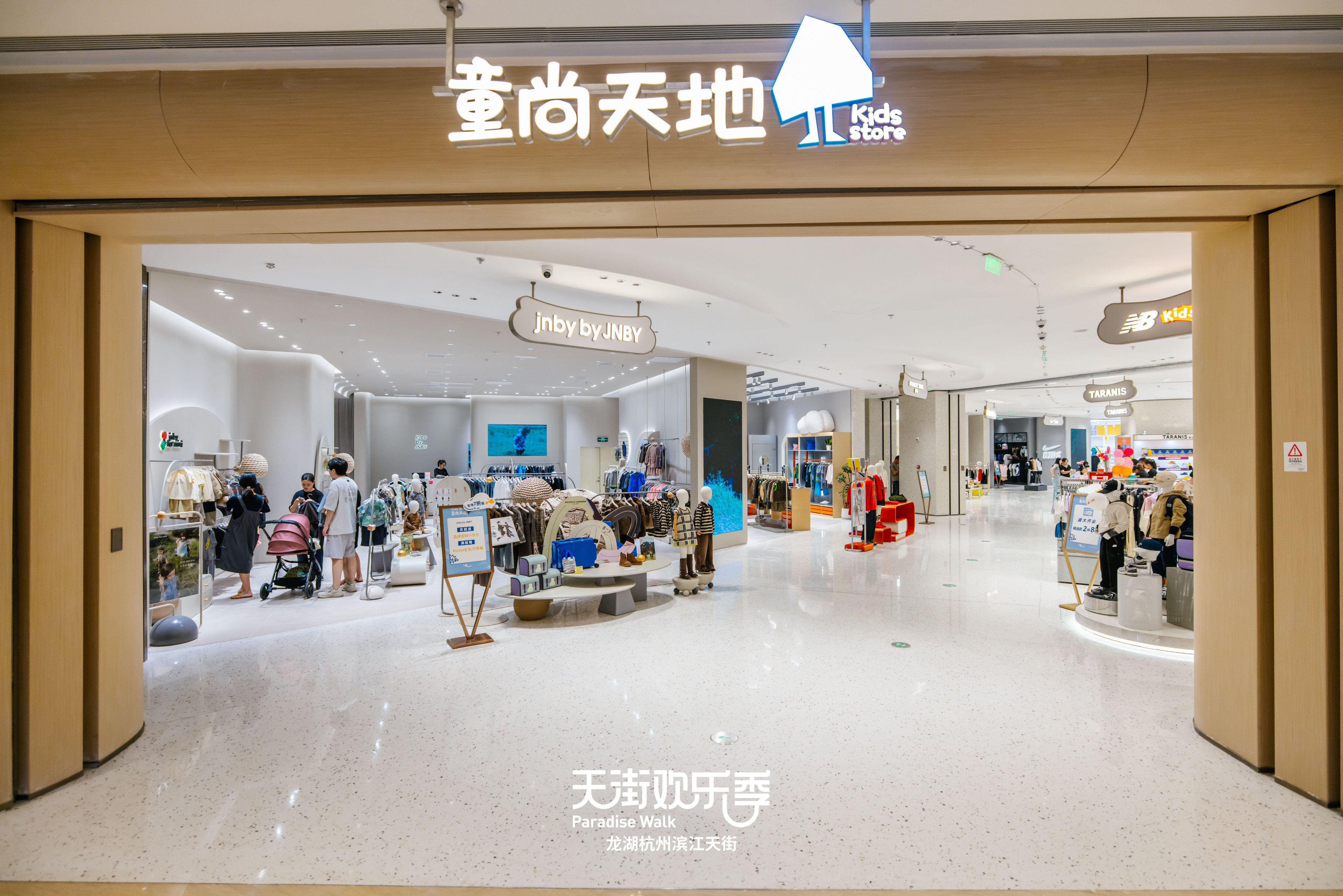 现代购物中心内部多层结构，透明玻璃天窗顶棚和扶梯连接各楼层。